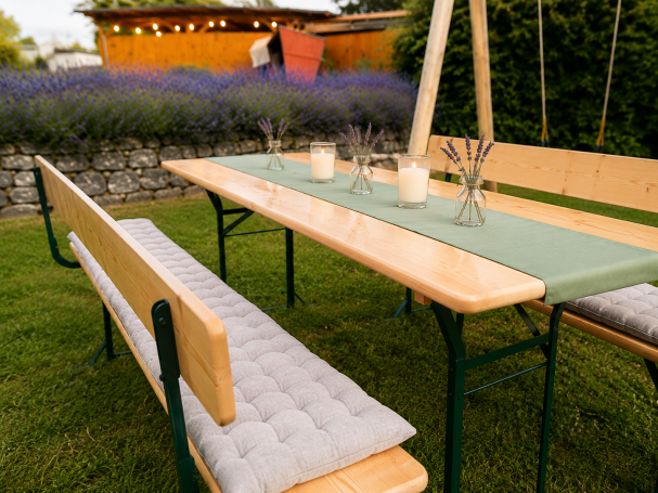 Bierzeltgarnituren mit Lehne mieten in Aschersleben Holztisch mit Bänken im Garten, umgeben von Lavendel und grünen Pflanzen.
