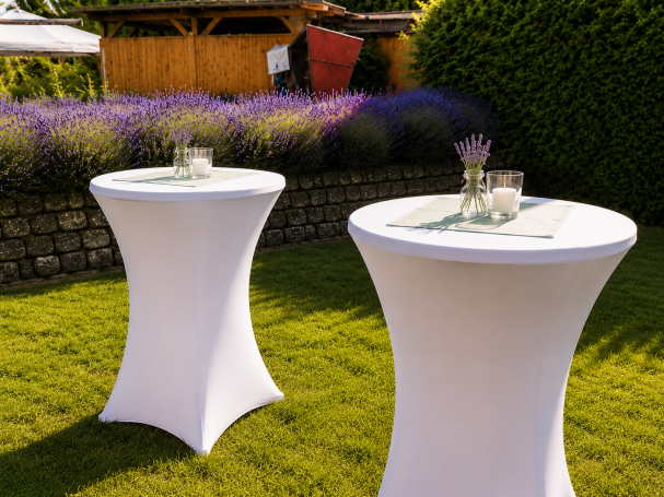 Stehtisch mieten Aschersleben Holztisch mit Bänken im Garten, umgeben von Lavendel und grünen Pflanzen.